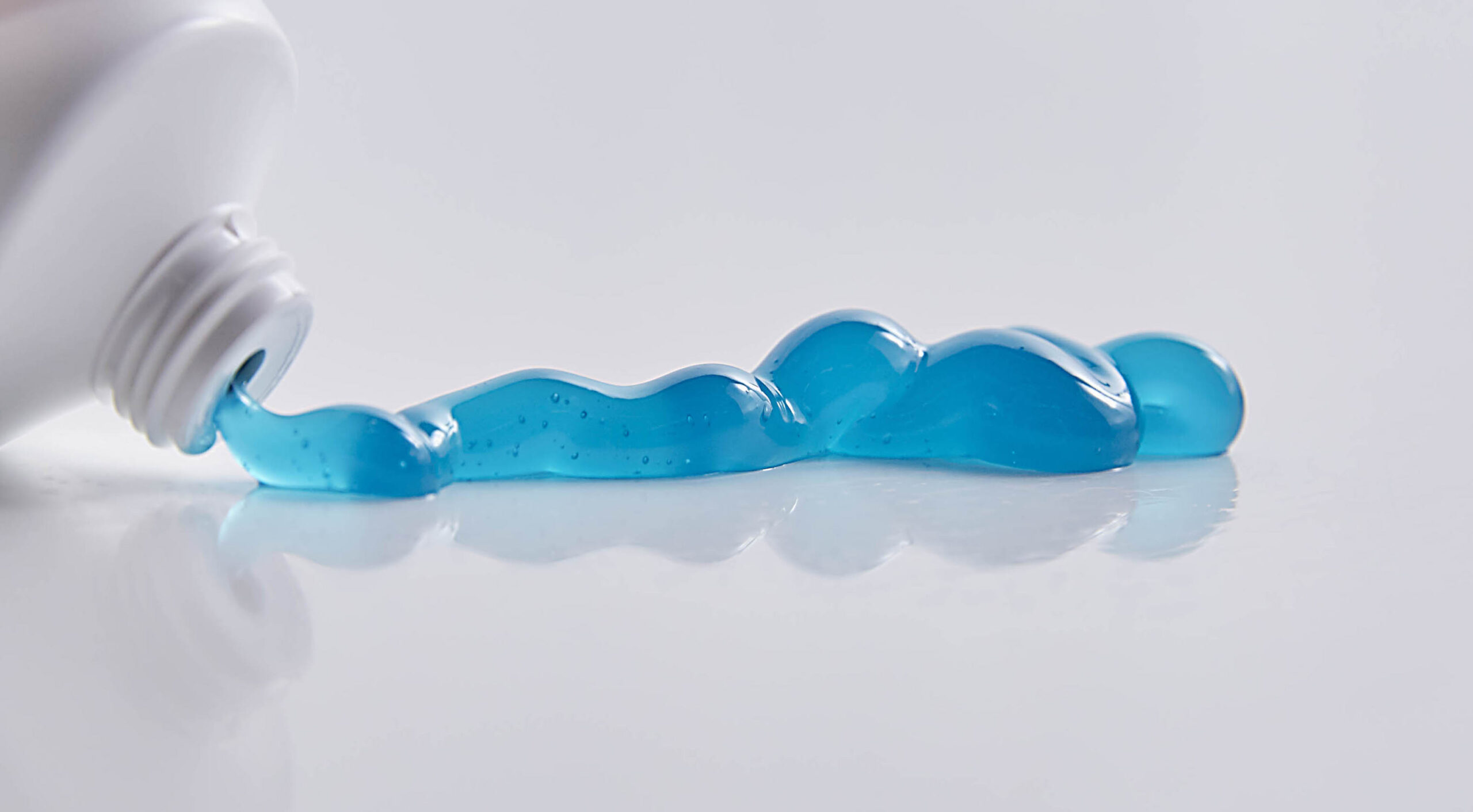 bluem Toothpaste with calcium fluoride being squeezed out of tube