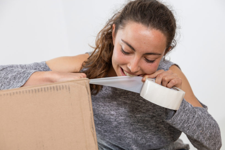 Woman ripping tape with her teeth