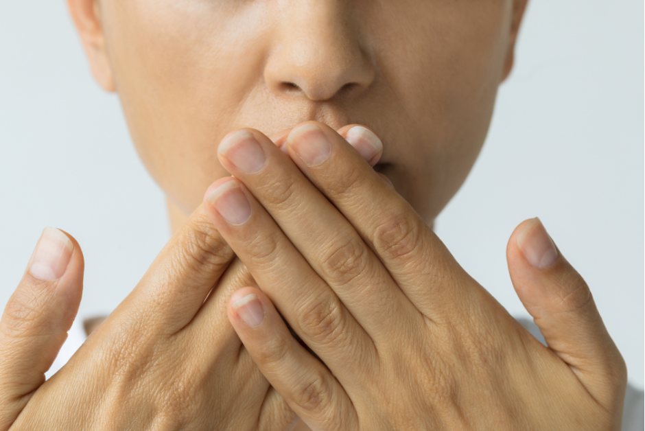 Lady with bad breath hands over mouth