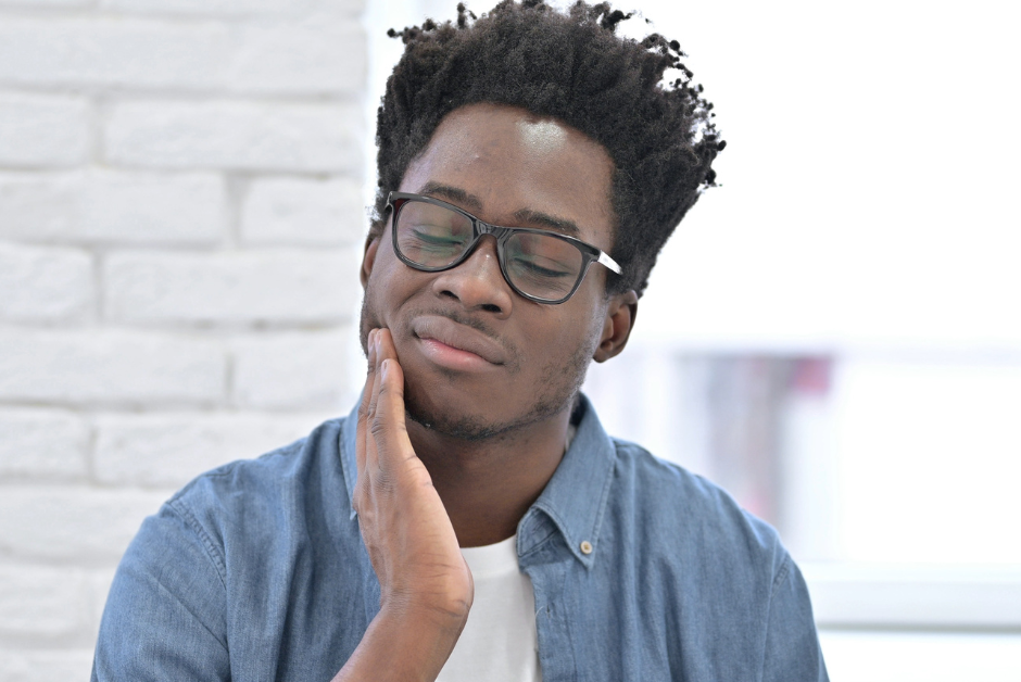 Man with mouth ulcer holding his cheek