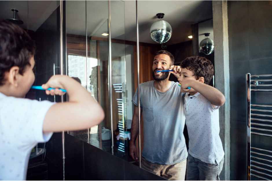 Man and boy brushing teeth